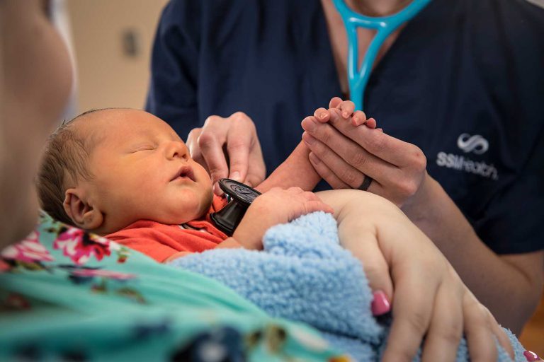 A nurse checks a baby's heartbeat